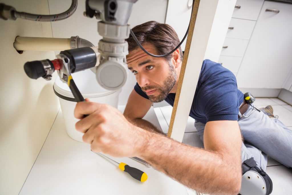 A Plumber Fixing a Pipe