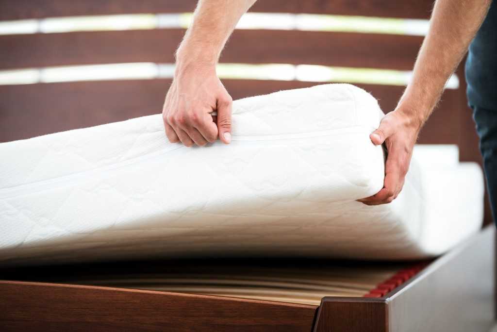 Young Man Checking the Quality of Mattress