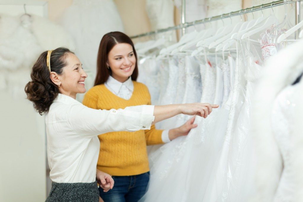 Bride-to-be being assisted in choosing a wedding dress