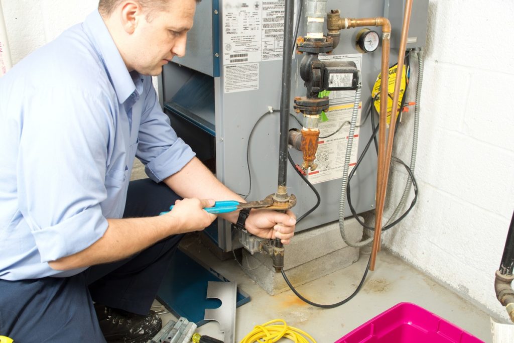 Plumber fixing a furnace