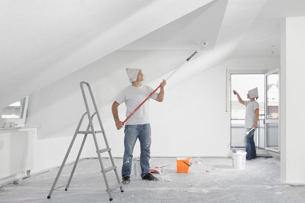 men repainting attic