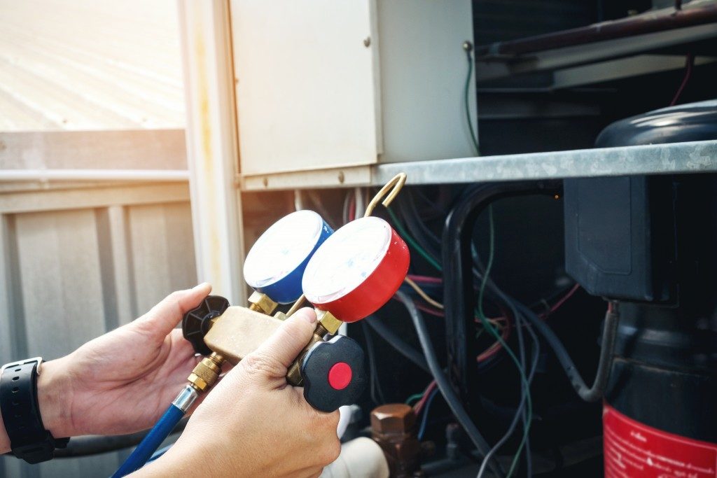 person checking meters of water heater