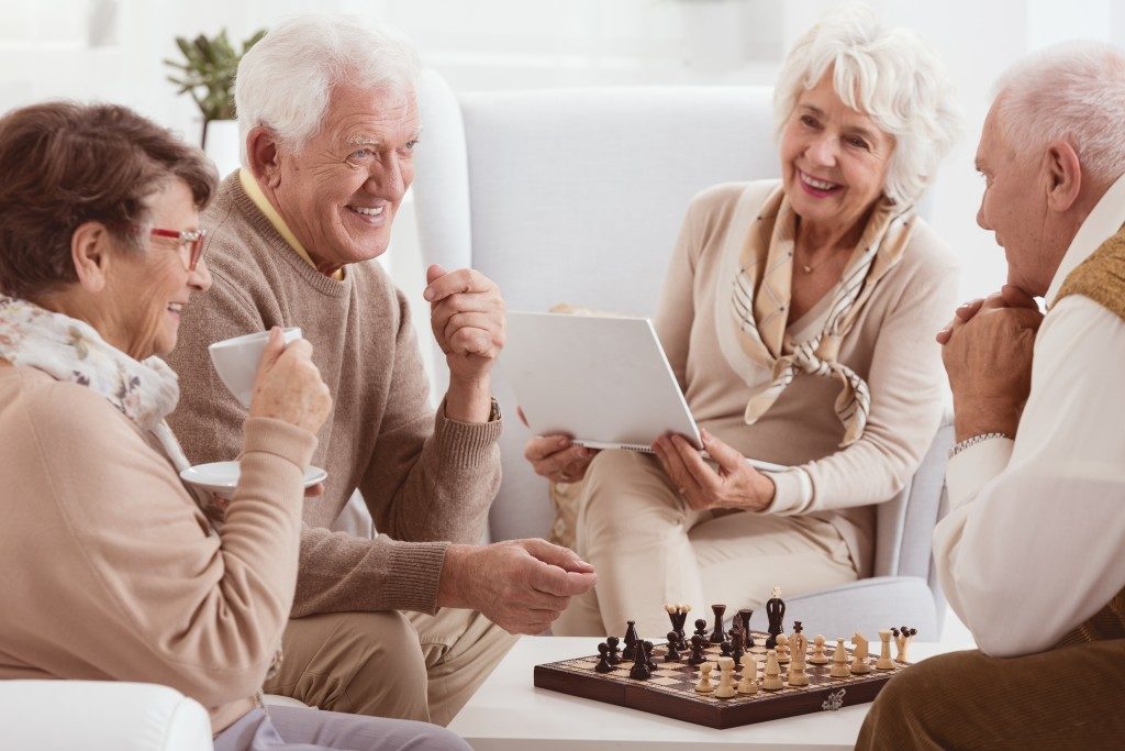 elderly peoplehaving coffee and playing chess