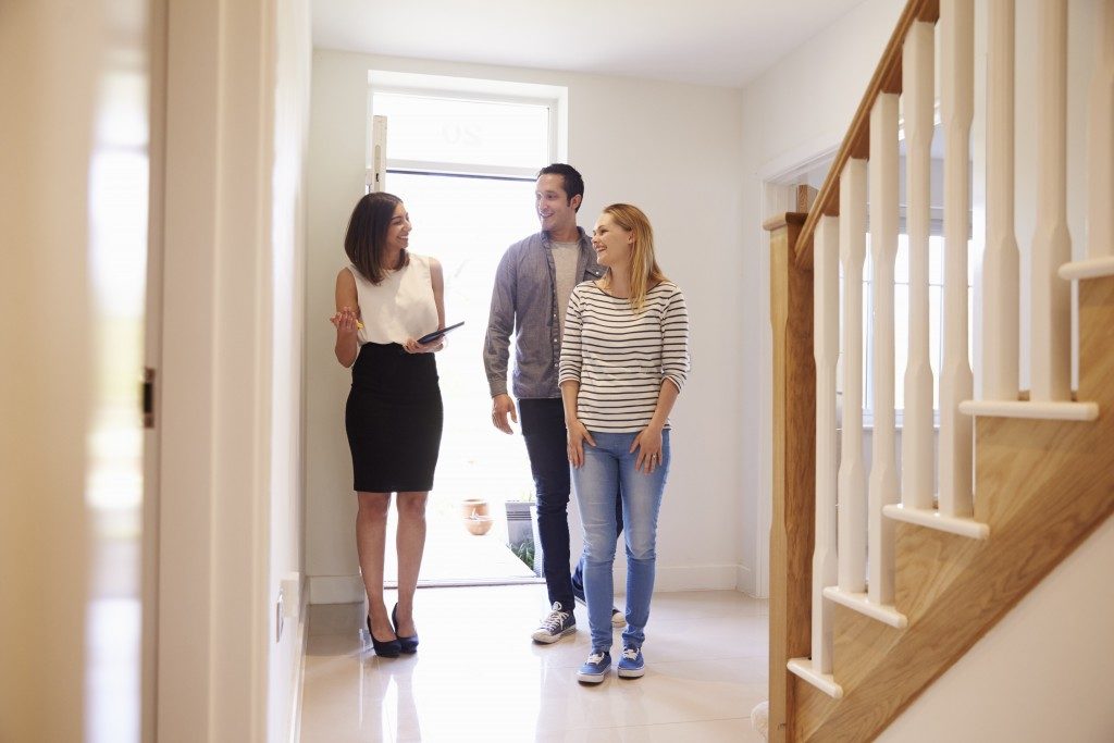 couple checking out a house with real estate agent