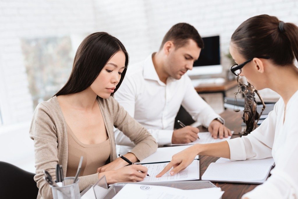 couple signing divorce papers infront of lawyer