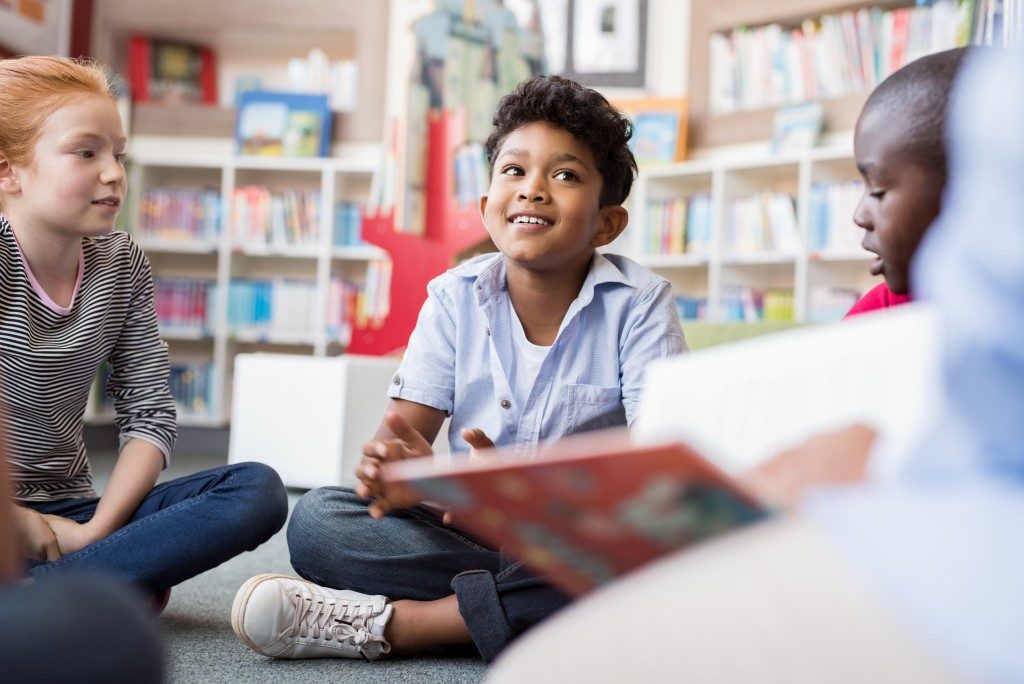 kids sitting on the floor listening to a storytelling