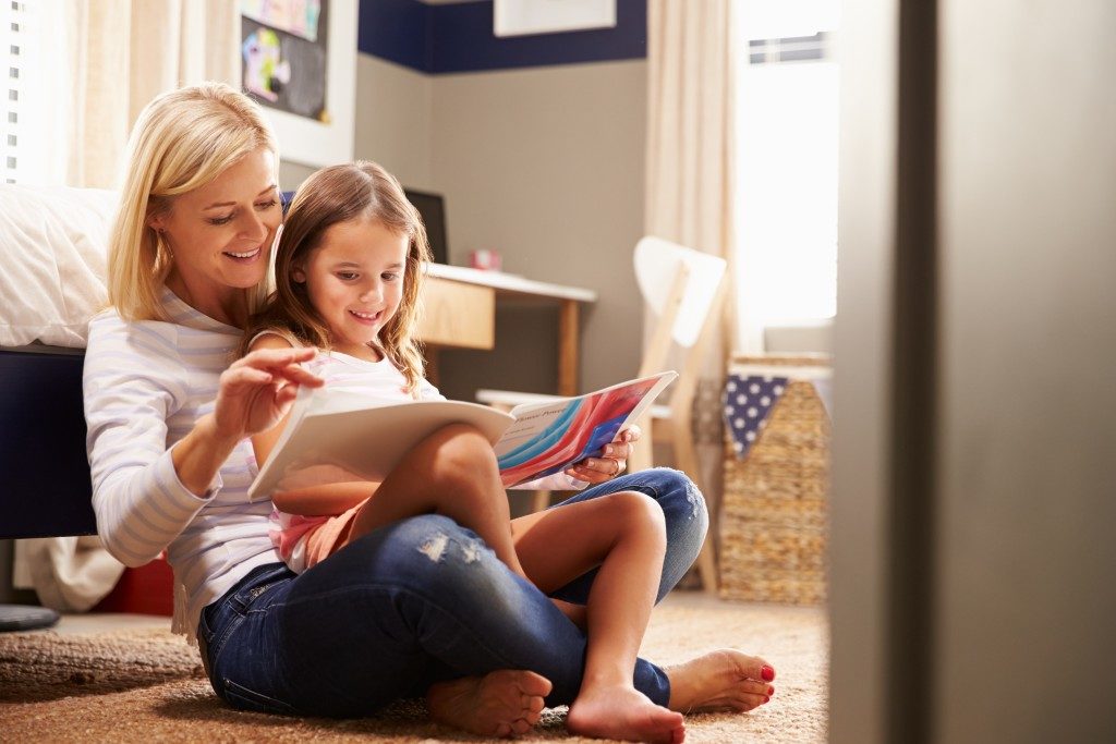 Mother reading with young daughter