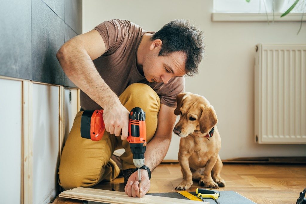 Man building something with his dog