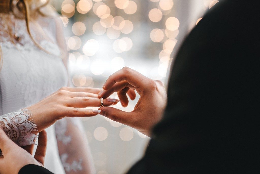 groom putting a ring on his bride