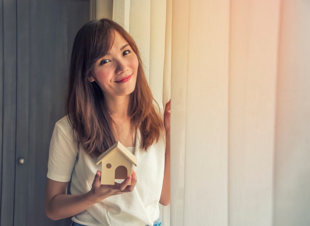 girl holding a small house