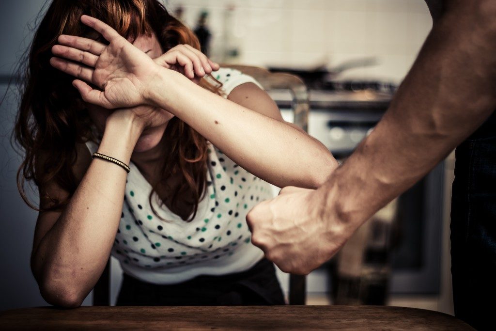 Woman covering her face in fear of domestic violence