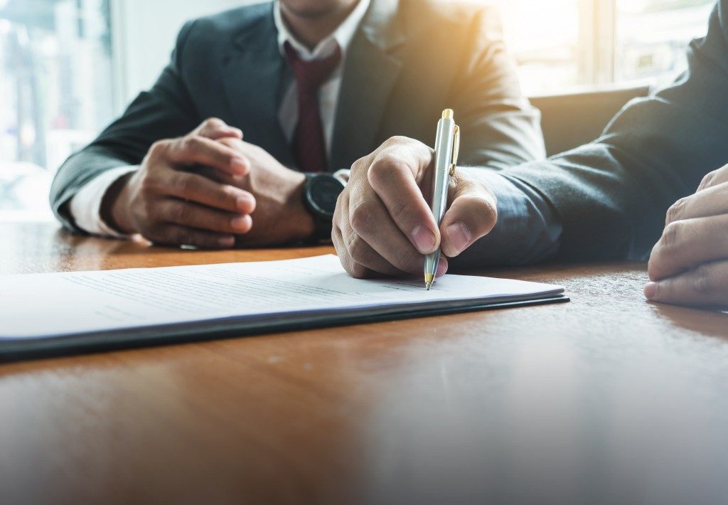 man signing a document