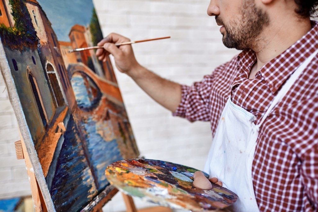 Artist painting landscape with oilpaints