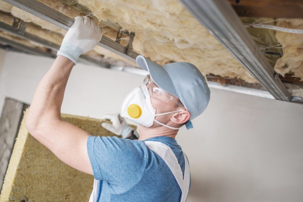 man installing insulation in a garage