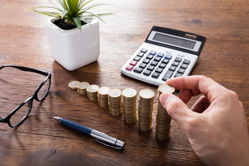 stacked coins, calculator and a pen