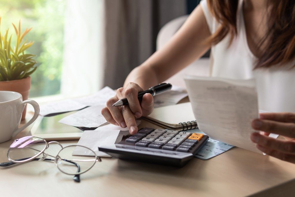 Woman computing her bills with a calculator