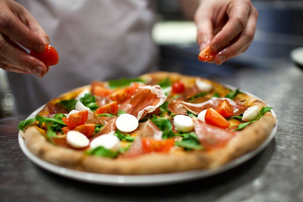 Chef in a restaurant preparing pizza