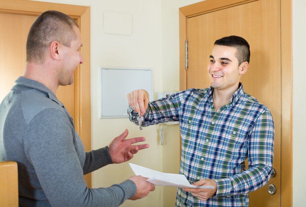 man handing keys and contract to renter