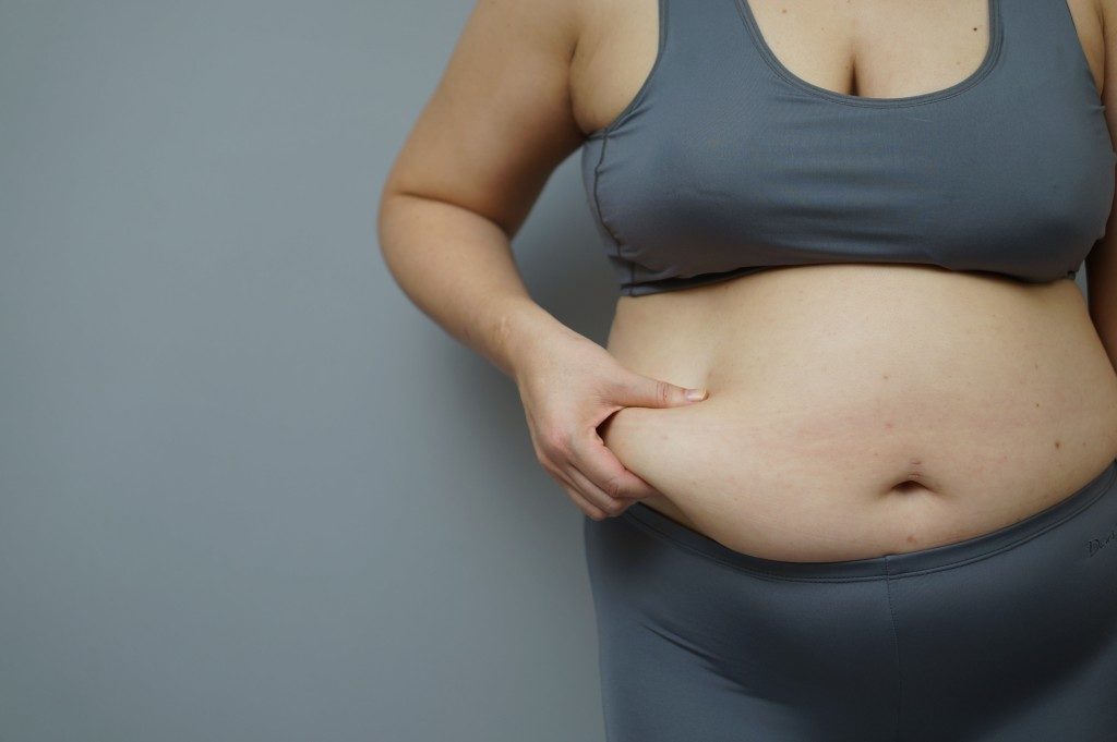 woman pinching her belly fat