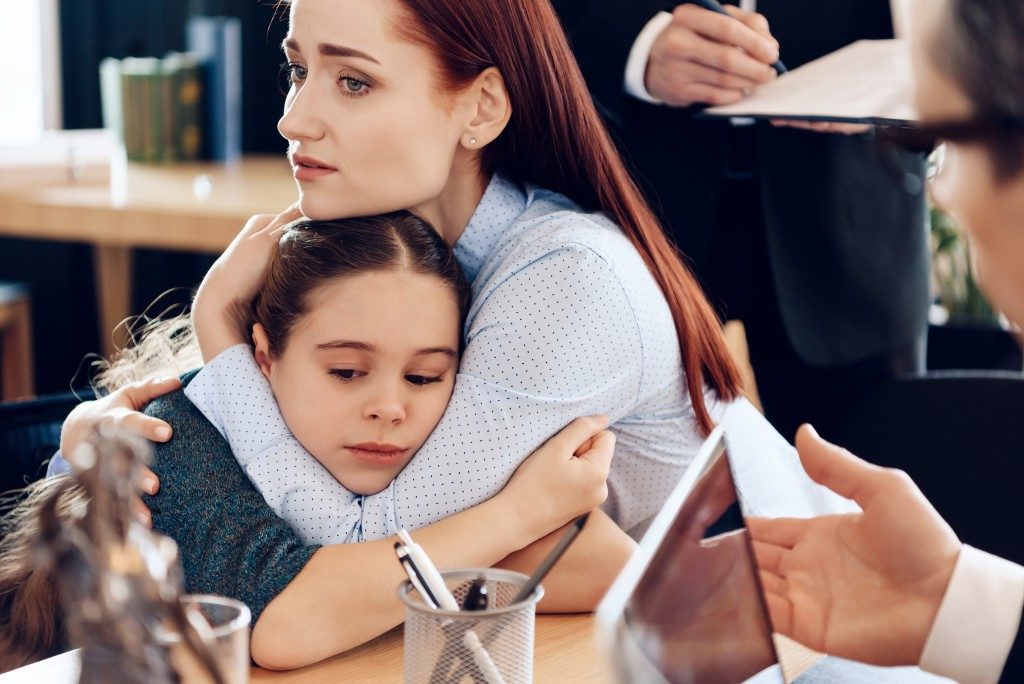 mother and daughter hugging during discussion of divorce