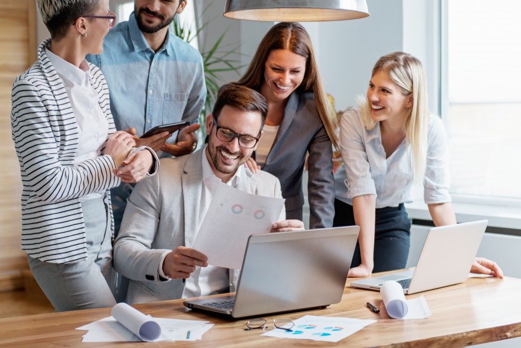 Employees in a huddle around a laptop