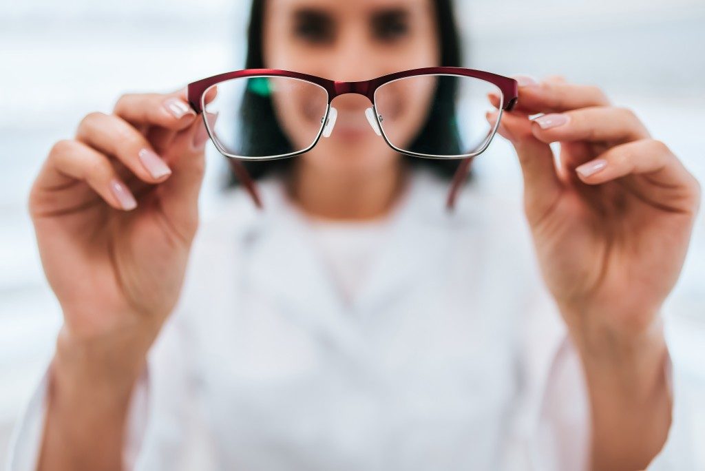 woman holding a pair of eyeglass