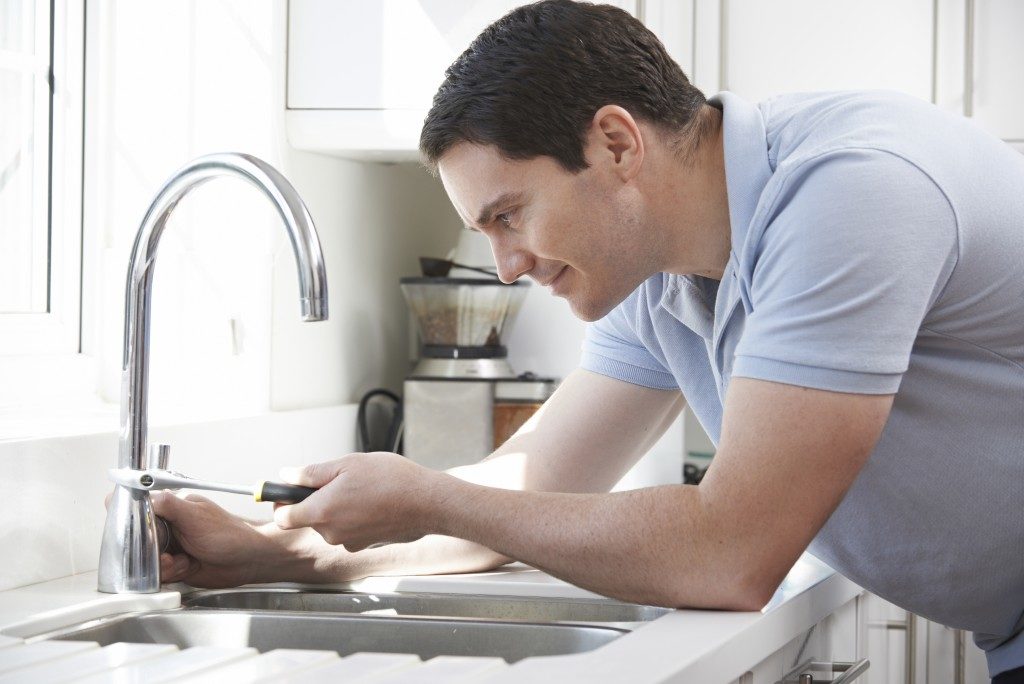 man repairing faucet