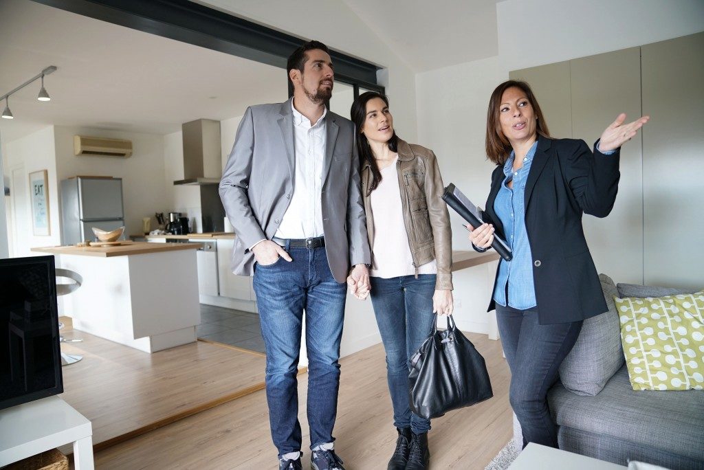 couple with real estate agent at house viewing