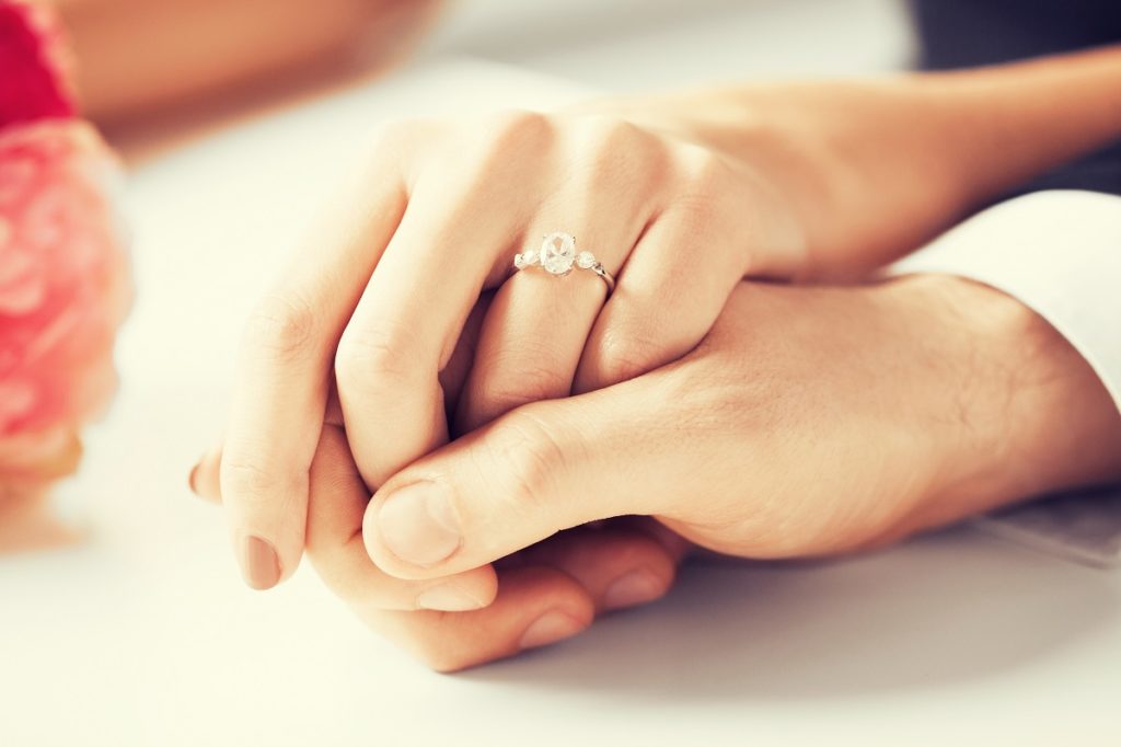 engaged couple holding hands