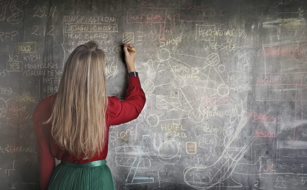 woman writing on a black board