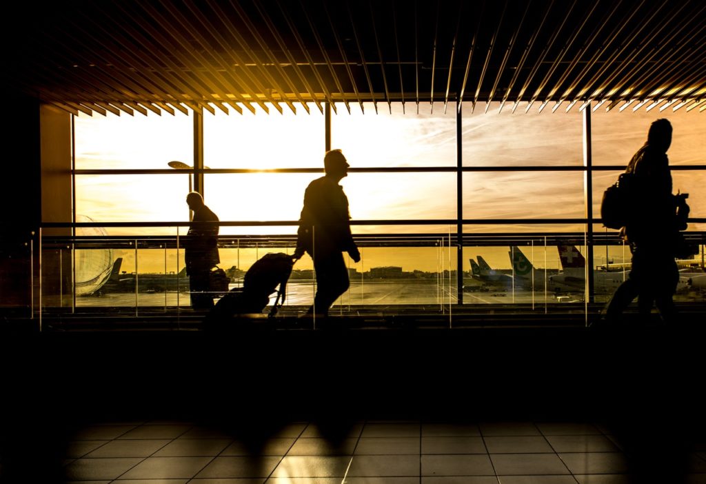 airport terminal with silhouette of people walking through