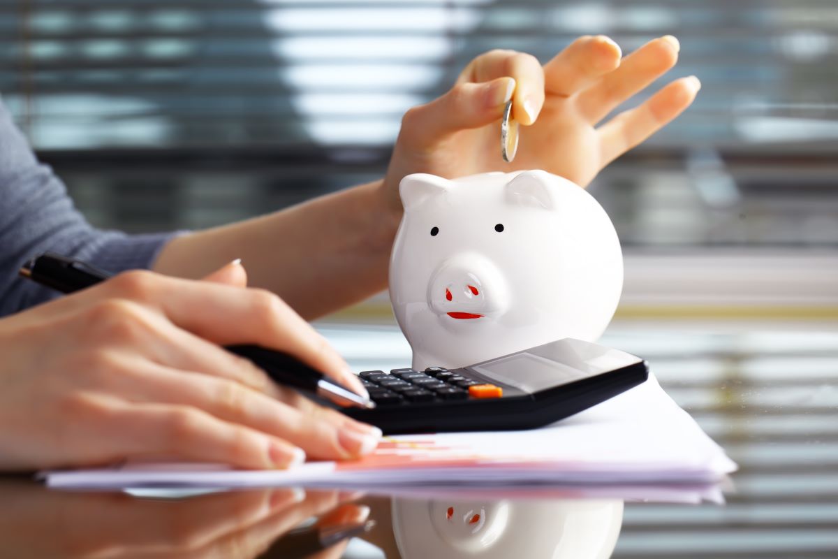 man putting coin in piggy bank