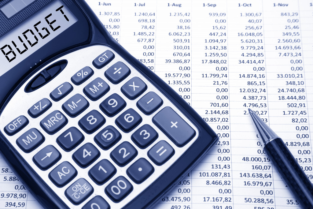 A financial document and a calculator with Budget on its screen