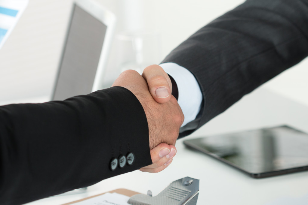 Business handshake. Two businessman shaking hands with each other in the office.