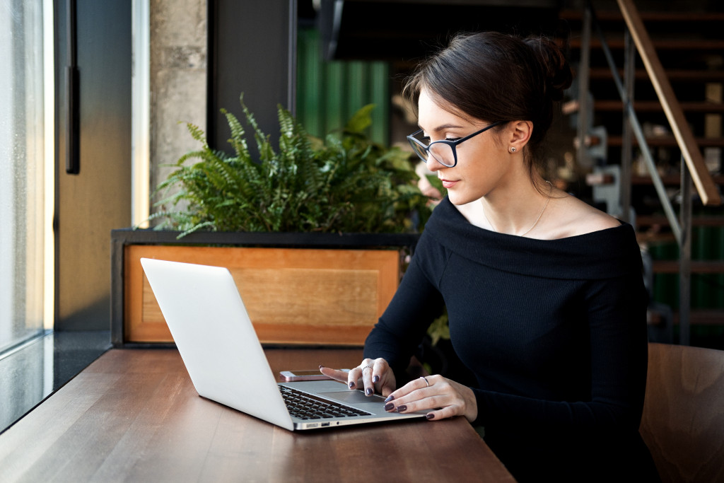 A business owner manages her small business online using her laptop
