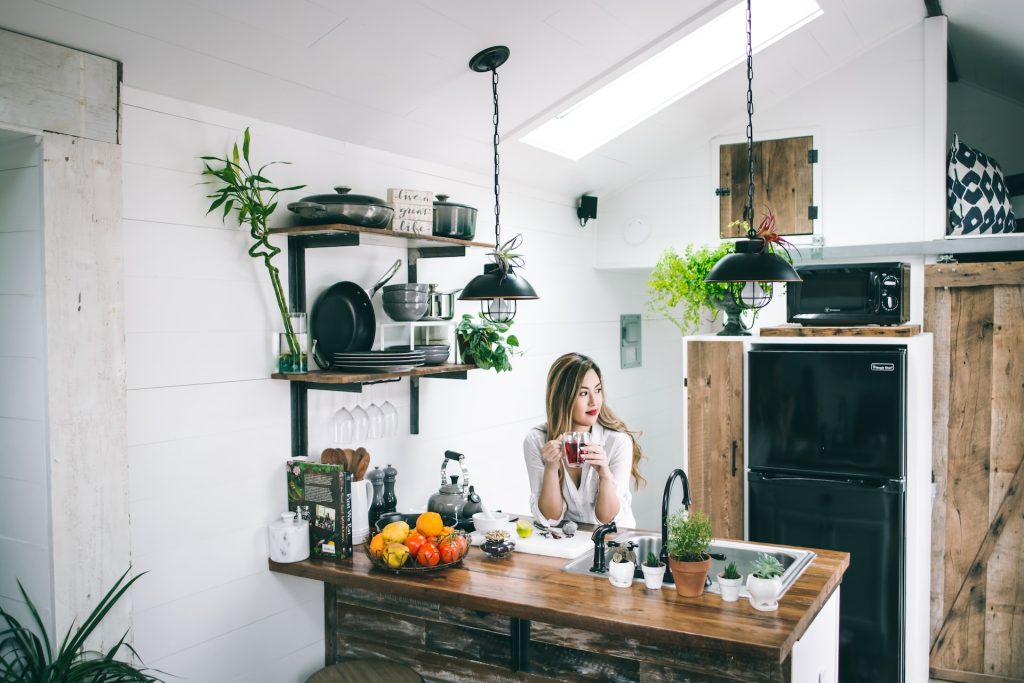 woman having coffee on kitchen countertop